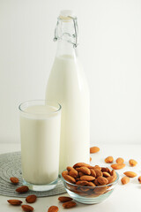 A glass with almond milk and the bowl with almonds