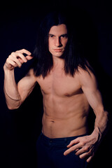 handsome young man with long hair naked torso on black background smiling, lifestyle people concept