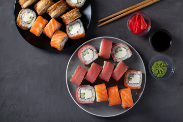 Asian food with sushi set of salmon, tuna and eel with philadelphia cheese on a dark background. Top view