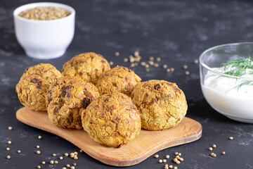 Falafel balls with coriander and parsley on a black background. Fresh vegetarian food. Vegetarian baked falafel with sauce.Healthy food.