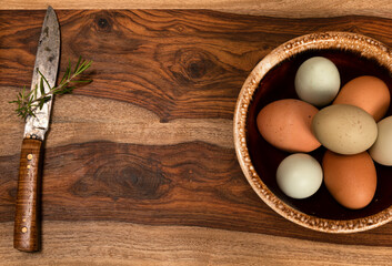 Background Featuring a Bowl of Colorful Eggs on a Cutting Board with a Handmade Knife