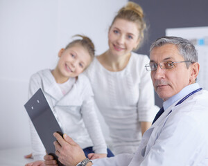 Fototapeta premium Little girl with her mother at a doctor on consultation