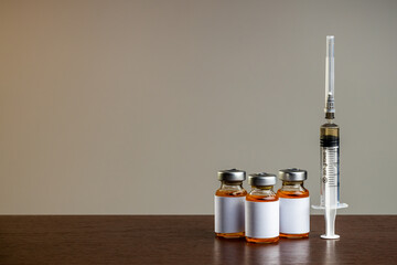 medical vaccine vials or bottles on table top over gray background. blank vial template for label