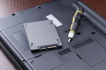 laptop repair service concept. man repairing or upgrading laptop hardware. person using screwdriver...