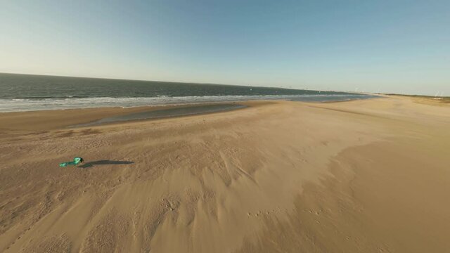 A drone view of the sea surrounded by a beach under the sunlight in Vrouwenpolder, the Netherlands in 4K