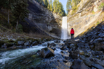 Girl watching a beautiful waterfall in Canadian Nature during winter. Taken in Brandywine Falls,...