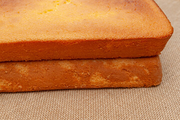 Homemade Sponge Cake, in Portuguese Pão de Ló. Top of the baked cake dough. Isolated on jute background. Front view
