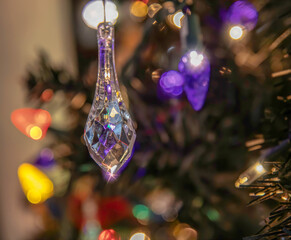 Crystal pendant Christmas decoration hanging in tree reflections and starry lights