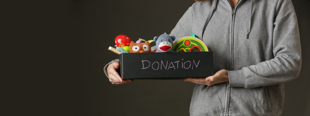 Volunteer women holding donation box with various children's toys