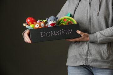 Volunteer women holding donation box with various children's toys