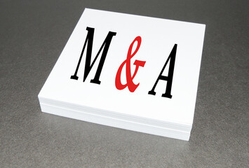 Mergers and acquisitions text ON a WHITE PAPER BLOCK, ON a Black background