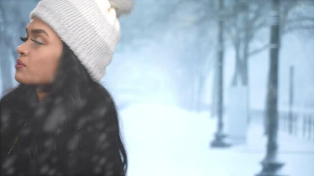 Curious Asian woman walking left to right snow looking for someone she's supposed to meet - walks out of frame