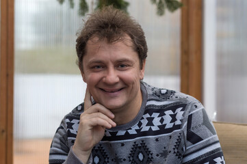 Happy handsome man in casual clothes resting in an annex at home