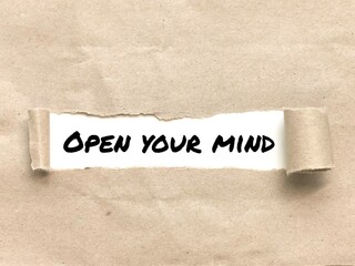 Phrase OPEN YOUR MIND appearing behind torn brown paper.For background purpose.