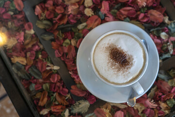 milk foam, white cup of coffee on floral background