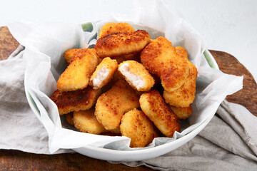 Fried crispy chicken nuggets with ketchup on wooden board