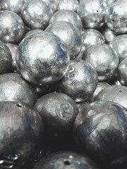 A vertical shot of lead balls sinkers for fishing in a bu