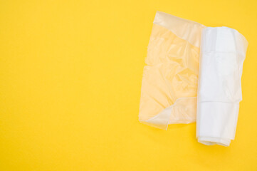 A top view of the plastic bags on a yellow surface - space for text