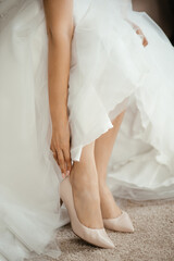 Fototapeta na wymiar woman bride straightens shoes with hand sitting