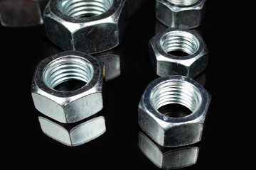 several large metal nuts on a black background