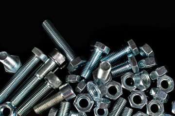 metal bolts and nuts group on black background