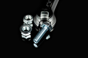several wrenches next to nuts and bolts on a black background