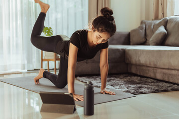 Obraz premium Young Training at home, woman in sportswear doing workout at home.