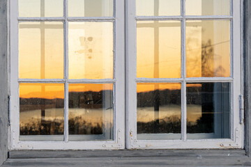 sunrise above lake mjøsa reflected in old window