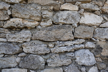 Ancient stone wall. Weathered rough surface of old masonry. Vintage texture great for background and design.