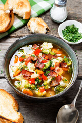 Soup with broccoli and cauliflower served with smoked bacon and toasted bread.	