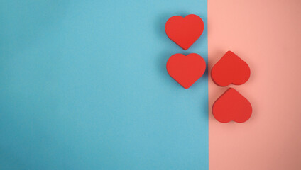 Four red hearts on pink and blue background