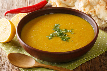 Shorbat adas is a vegan lentil soup from Middle East closeup in the bowl on the table. Horizontal
