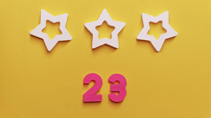 February 23 holiday background. 23 figure figurine made of plastic, a symbol of Russia. Men's Defender of the Fatherland Day.