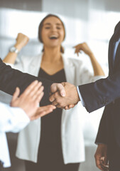 Unknown businesspeople are shaking their hands after signing a contract at meeting, close-up. Business communication concept - 401748102