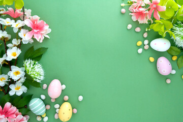 Easter eggs and flowers green background flat lay with copy space