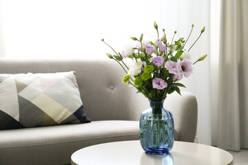 Bouquet of beautiful Eustoma flowers on table in room. Space for text