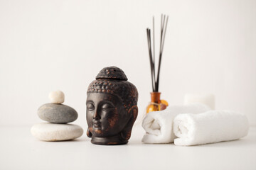 Clay buddha head aroma lamp, aroma sticks, stone composition and spa towels – spa composition on...