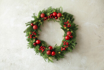 Beautiful Christmas wreath with festive decor on light wall