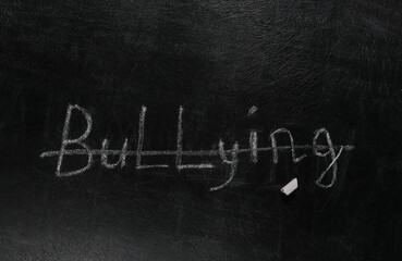 Obraz premium Strikethrough word bullying written chalk on a blackboard
