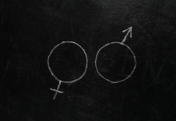 Gender female and male symbol hand drawn in chalk on a blackboard