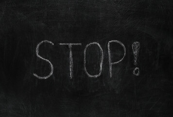 Word STOP! chalk hand drawn on blackboard