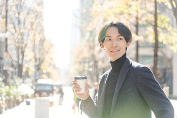 コーヒーを飲む男性 冬 都会