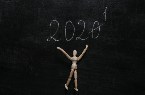 New year's transition from 2020 to 2021 on chalk board and wooden puppet