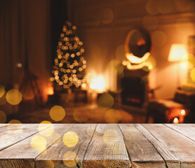 Empty wooden surface and blurred Christmas tree in room on background, bokeh effect. Space for design