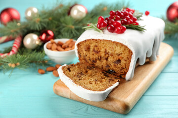 Fototapeta na wymiar Traditional classic Christmas cake decorated with cranberries and rosemary on turquoise wooden table