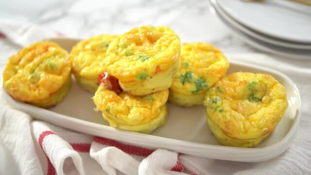 Step by step. Bacon and cheese egg muffin on a white serving plate.