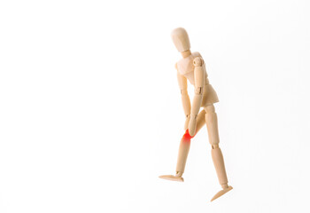 Wooden puppet with leg pain isolated on white background. Osteoarthritis
