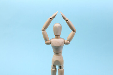 A wooden puppet holds arms above its head. Protection concept