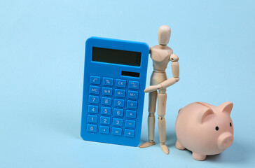 Wooden puppet with calculator and piggy bank on blue background. Costing, save money, economics