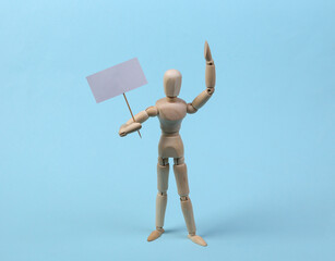 Wooden mannequin puppet standing with blank sign protesting on blue background